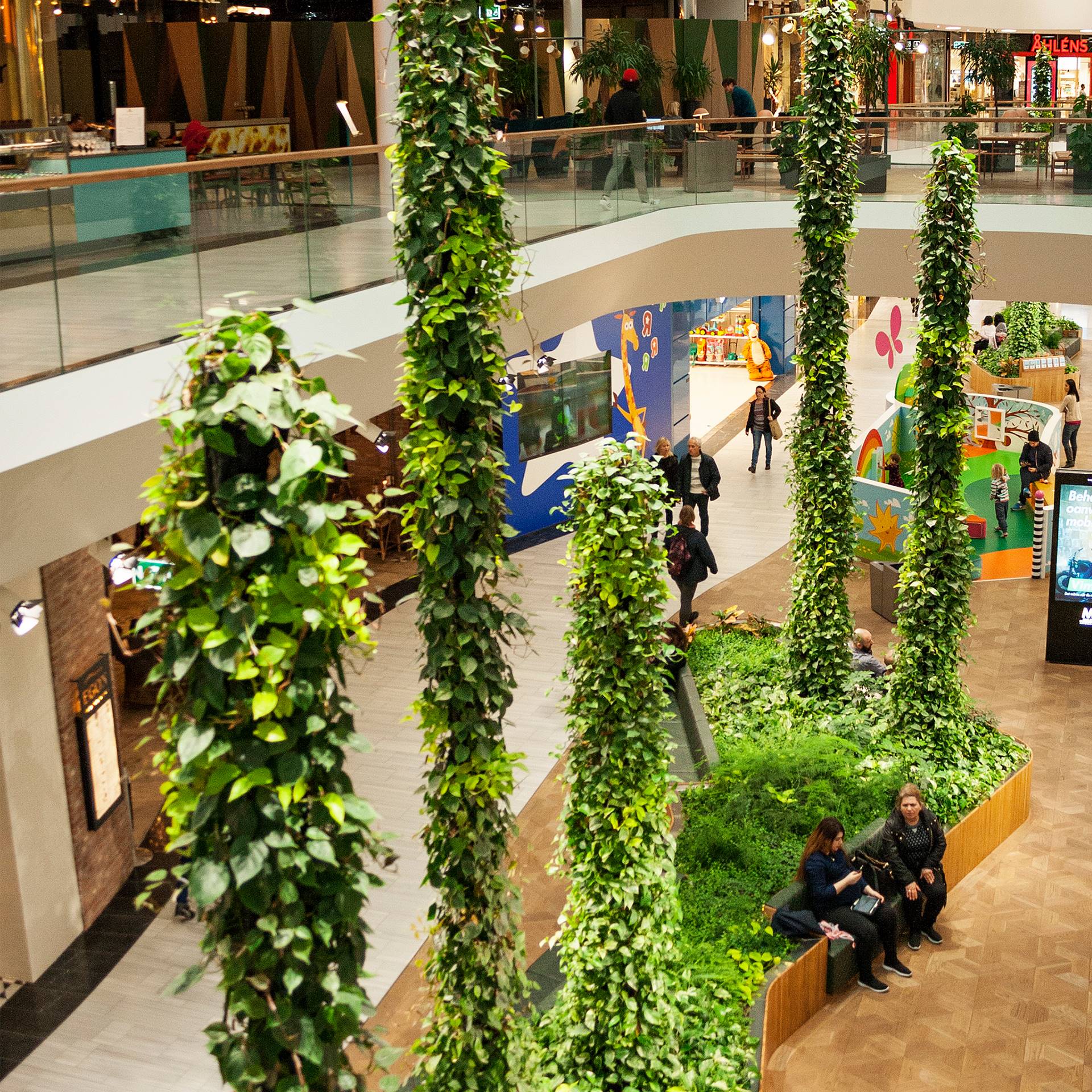 Een plant in de vorm van een pilaar dient als eyecatcher in dit winkelcentrum